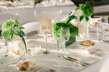 Elegant wedding reception table setting with beautiful floral centerpieces and dinnerware in the afternoon light