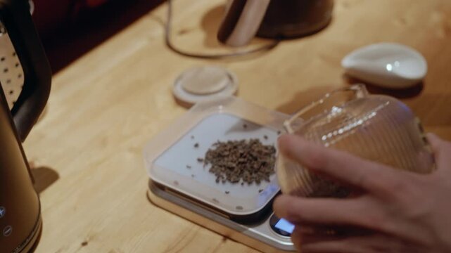A professional tea maker measures out the perfect tea portion using a scale in a boutique tea caf&eacute;.
