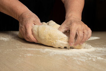 Raw homemade bread, preparing and kneading the bread before baking, on a wooden surface, selective...
