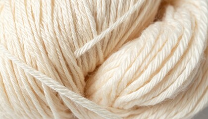 Fototapeta premium Soft, creamy wool yarn coils into a textured ball, evoking warmth and cozy handmade creations for winter crafting.