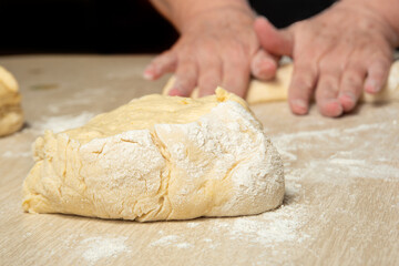 Raw homemade bread, preparing and kneading the bread before baking, on a wooden surface, selective...