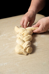 Raw homemade bread, preparing and kneading the bread before baking, on a wooden surface, selective focus.
