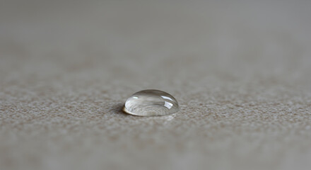 Captivating Liquid Orb Resting On Neutral Textured Surface Close-Up