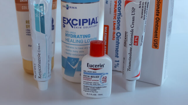 Close-up of several over-the-counter and prescription skin creams, ointments, and lotions isolated against a white background.  Dermatology and skin product concept.
