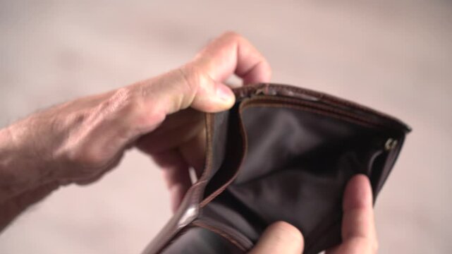 Close-up of elderly man revealing empty wallet