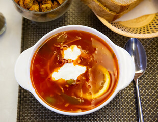 Traditional Russian meat soup solyanka with assorted meat and sausages and vegetables