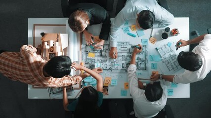 Top aerial view of project manager or civil engineer writing at blueprint and planning building design. Aerial view of architect working together at meeting table with document placed. Alimentation.