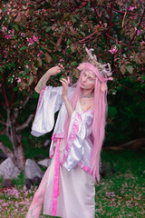 Deer dryad girl against the background of a blooming pink apple tree