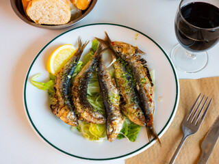Grilled on fire sardines served with vegetable salad, traditional andalusian dish