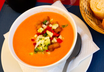 Delicious Spanish cold soup gazpacho from raw blended vegetables garnished with crispy croutons,...
