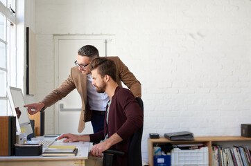 Men, creative and business on computer in office for research, planning and ideas as web designer...