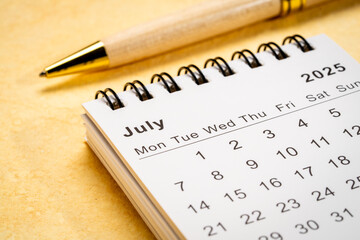 July 2025 - small spiral desktop calendar, time and business concept