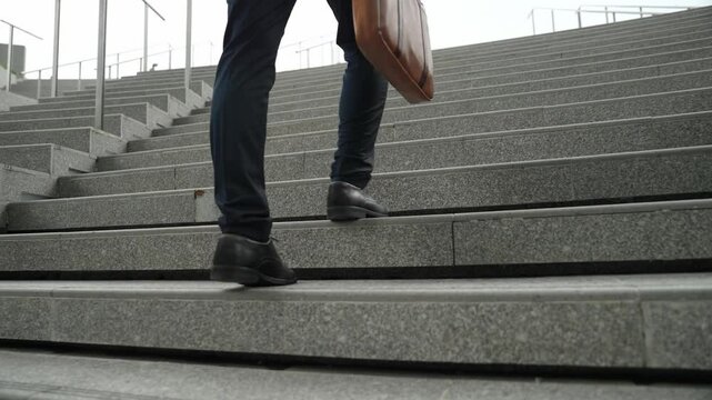 Top view of smart business man walking up stairs with bag in the hand. Professional project manager climb up the stair and going to workplace. Increasing skill, getting promotion, traveling. Exultant.