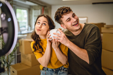 couple v-loggers shooting a video while hold and show piggy bank