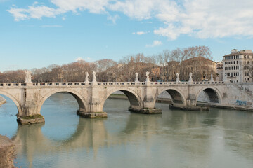 Scenic view of Ponte Sant Angelo bridge over Tiber River in Rome during daytime with reflections on...