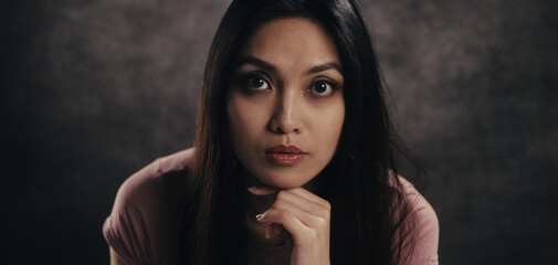 Woman gazing intently with hand under chin