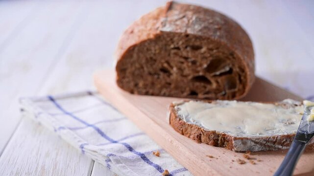 Healthy wholemeal bread with butter on a wooden table. multigrain sourdough bread with butter on a light kitchen table