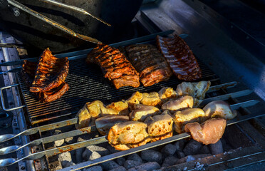 Barbecue cooking with chicken and ribs over charcoal. A scene showcasing grilling during summer with delicious roasted food preparation in an outdoor setting