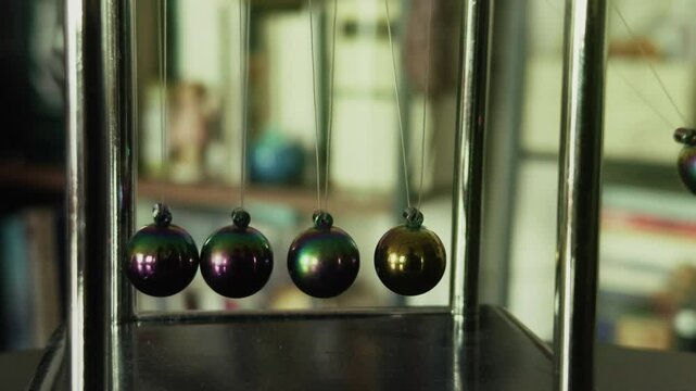 Newtons Cradle and Blurry Books on Shelves