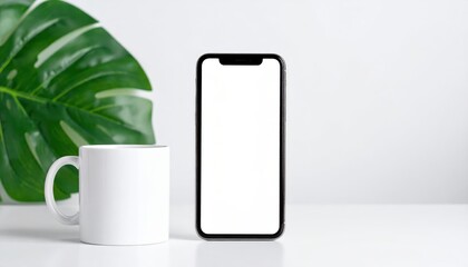 A smartphone rests beside a mug, nestled among lush green leaves on a bright, minimalist surface, evoking a moment of tranquil relaxation.