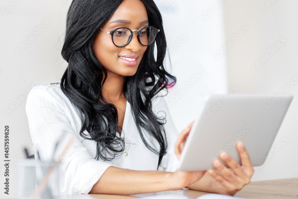 Poster working online concept. positive millennial black lady using tablet computer at modern office. afric