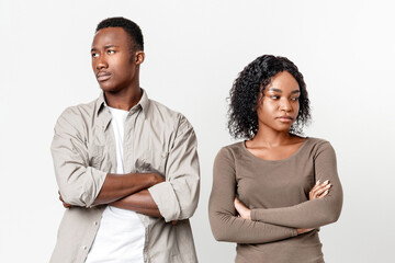 Break up, troubles, misunderstanding in relationships or marriage. Upset african-american man and woman standing next to each other with arms crossed after fight, gray studio background