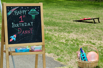Chalkboard Birthday Sign with UFO Drawing on Grass
