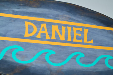 Painted Name Daniel on Blue and Yellow Decorative Surface
