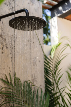 Luxury modern black outdoor shower in a lush tropical garden. 