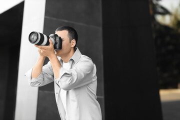 Male photographer with modern camera outdoors