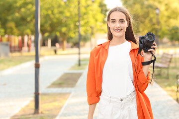 Fototapeta premium Young female photographer with modern camera in park