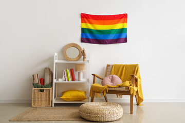 Interior of living room with LGBT flag, shelf unit and armchair