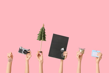 Journalist's female hands with Christmas fir decorations, notebook, camera and badge on pink...