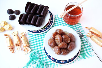 Traditional Turkish Candied Chestnuts designed in white plates on green napkin with chestnut honey