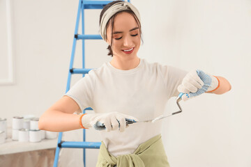 Young woman with putty knives in room