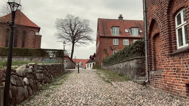 Street with old houses leading to the Domkirke church in Viborg, Denmark. The old city in Denmark. Traditional danish architecture. Midtjylland. Cityscape at dusk. Scandinavian street at sunset.