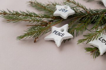 Christmas star with words JOY PEACE LOVE Group of air dry clay handmade Christmas decor on beige background. Children air dry clay activity handicraft idea. Preparing for Christmas holiday decorating