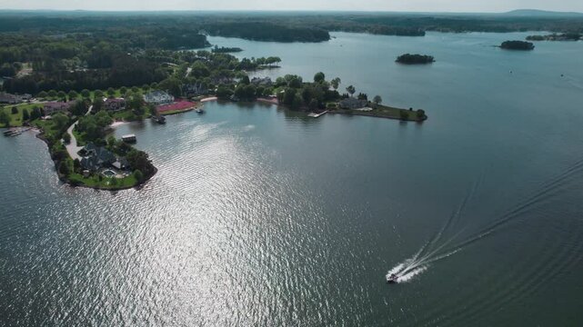 Pleasure boat passes shore and beautiful estates of Lake Norman