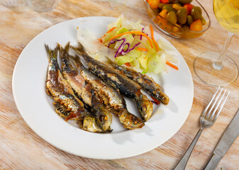 Crunchy charcoal grilled sardines served with fresh vegetable salad, typical Portuguese seafood appetizer