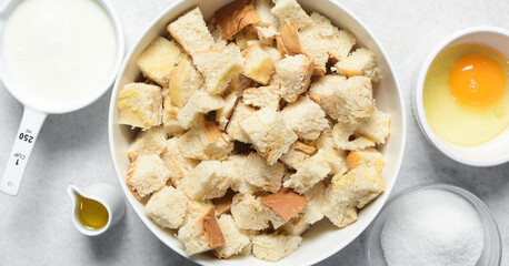 Overhead view of ingredients for making bread pudding, top view of mise en place of ingredients for making bread pudding, process of making bread pudding