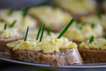 Egg spread on sliced ​​rolls with chives.
