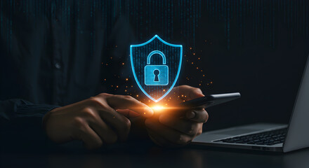 Cybersecurity Protection Digital Padlock Shield Concept with Person Using Smartphone on Laptop in Dark Background