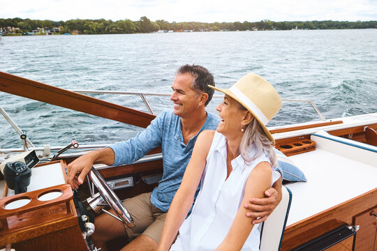 Man, woman and ocean adventure or together in boat on holiday, relax on cruise date for retirement travel. Mature, happy couple and water yacht for vacation with happiness, outdoor summer in Bali