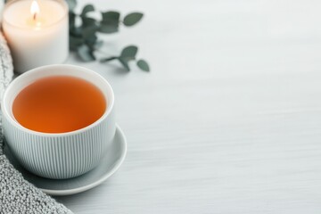 Relaxing herbal tea, burning candle, and eucalyptus on table: promoting self-care and mindfulness