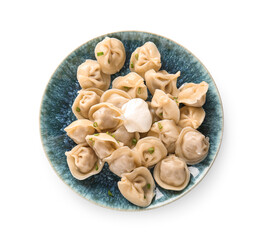 Plate of delicious boiled dumplings with sour cream and green onion on white background