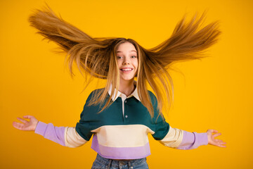 Joyful young woman in casual fashion expressing excitement with dynamic hair movement