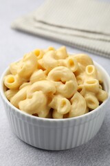 Delicious pasta with cheese sauce and fork on grey table, closeup