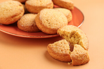 Plate with sweet cookies on brown background, closeup
