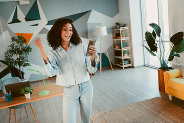 Young woman enjoying leisure time in a casual living space during daylight, expressing happiness...