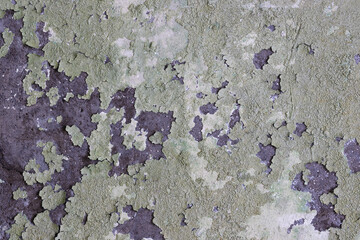 Peeling paint on the wall. Old concrete wall with cracked flaking paint. Weathered rough painted surface with patterns of cracks and peeling. High resolution texture for background and design. Closeup
